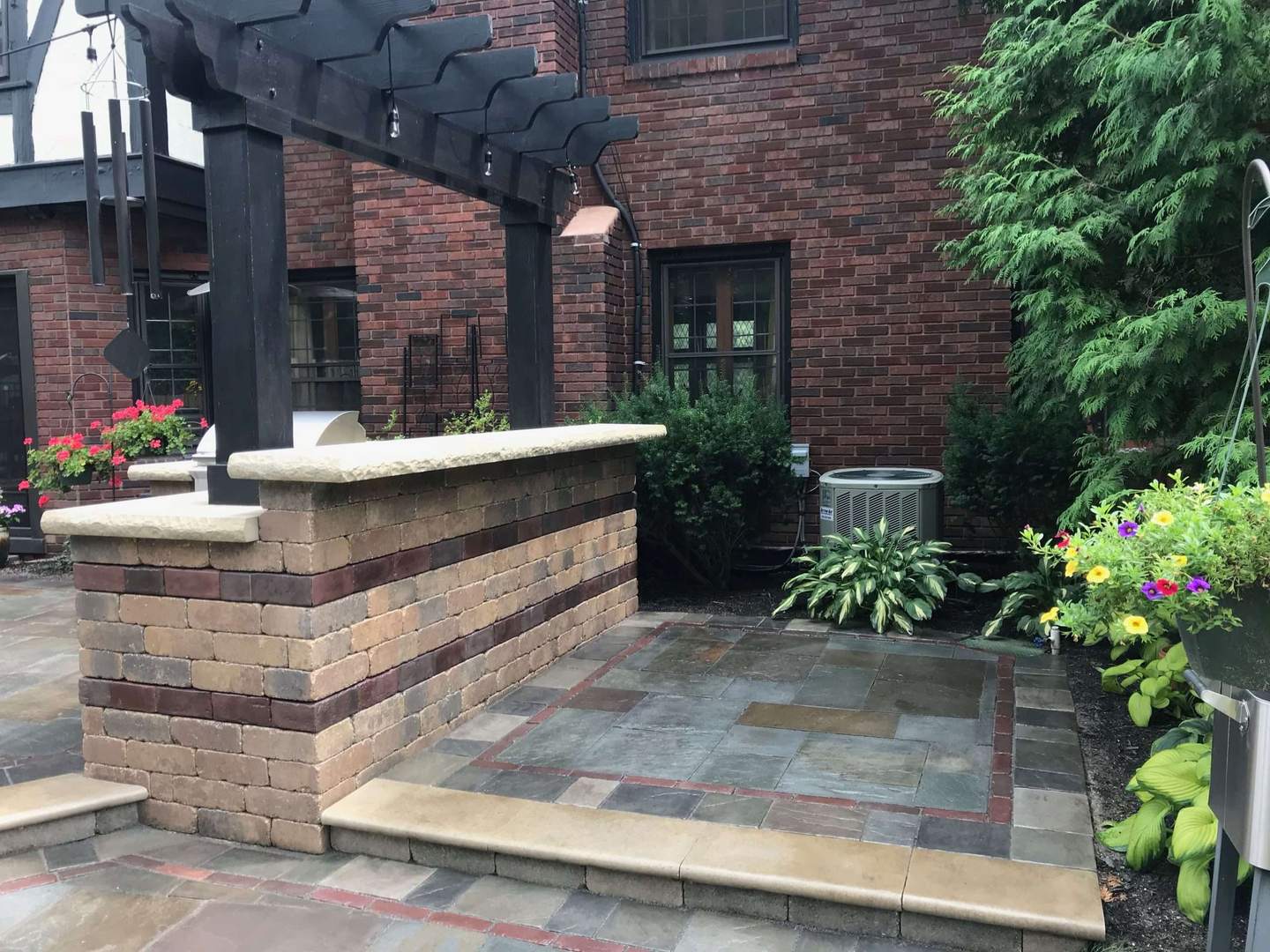 Stone outdoor kitchen and patio with pergola detail